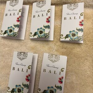 Avon Far Away Bali Perfume Sample Set with Blue and Pink Floral Accents.